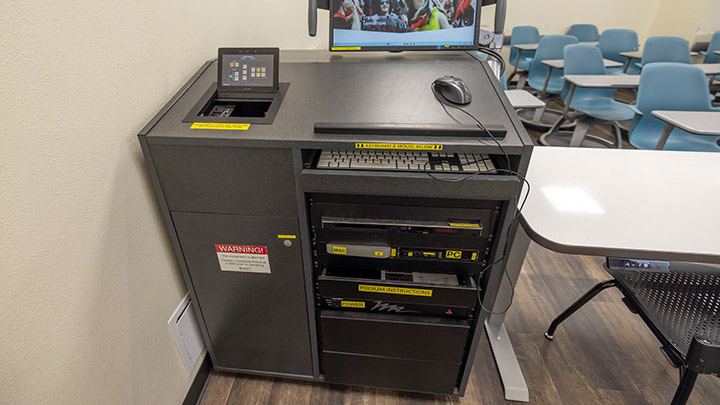 classroom instructor podium with integrated tech and projector