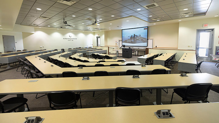 classroom with projection screen and podium in background