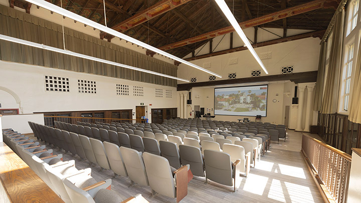 Back of the room facing the projection screen with stadium type seating