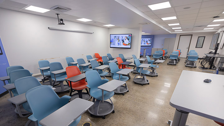 Front of classroom showing screens on walls