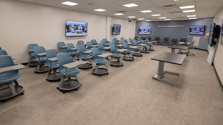 general view of classroom from the front, seating and screens on walls