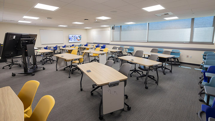 Front of classroom showing several desks and instructor space in the background