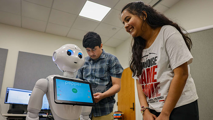 San Diego State students interact with Pepper the humanoid robot, part of AI research supporting pediatric mental health detection.